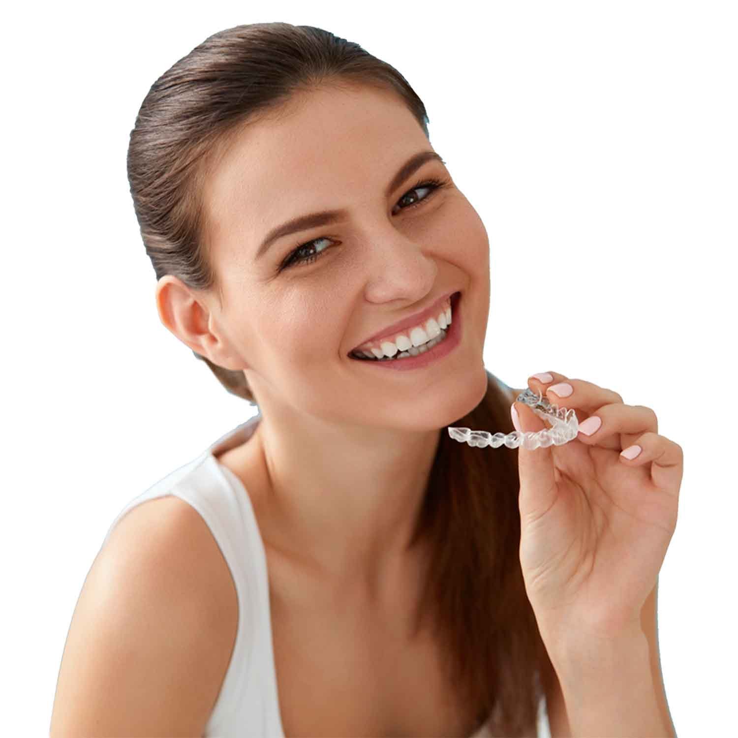 Am I a Candidate for Invisalign_ Young Woman Smiling Holding Clear Invisalign Aligners